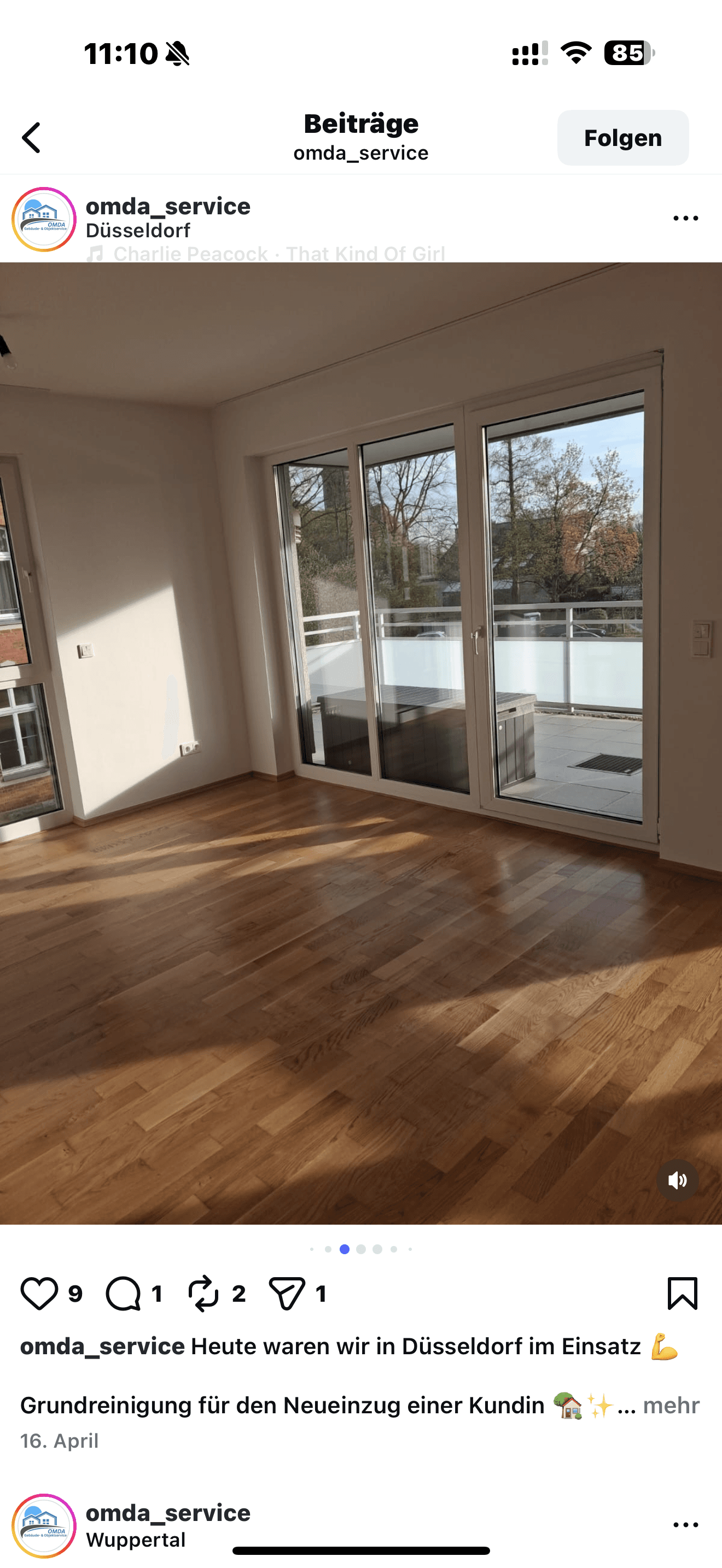 Lichtdurchfluteter, leerer Raum mit glänzendem Parkettboden und großer Glasfront zu einem sonnigen Balkon.